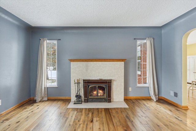 unfurnished living room featuring hardwood / wood-style floors, plenty of natural light, and a textured ceiling