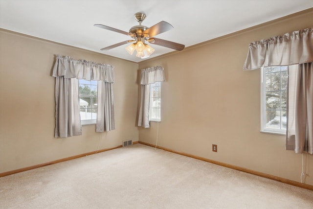 spare room with ceiling fan and carpet