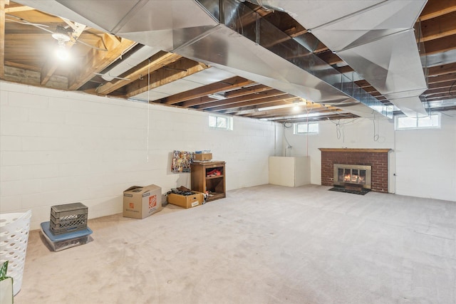 basement featuring plenty of natural light and a brick fireplace