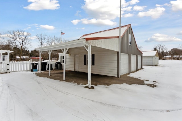 view of front of home featuring a carport, a garage, and an outdoor structure