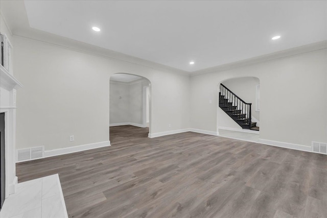 unfurnished living room with hardwood / wood-style floors and ornamental molding