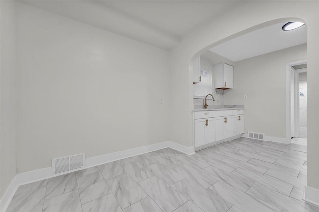 kitchen featuring white cabinetry and sink