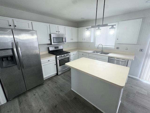 kitchen with sink, a center island, stainless steel appliances, decorative light fixtures, and white cabinets