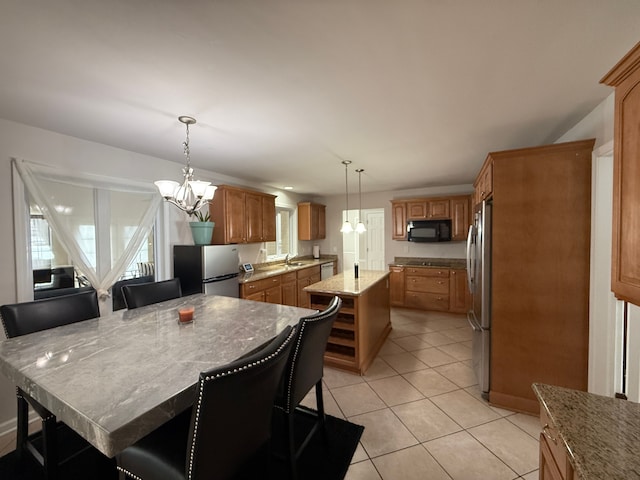 kitchen with a kitchen island, stainless steel refrigerator, and a breakfast bar area