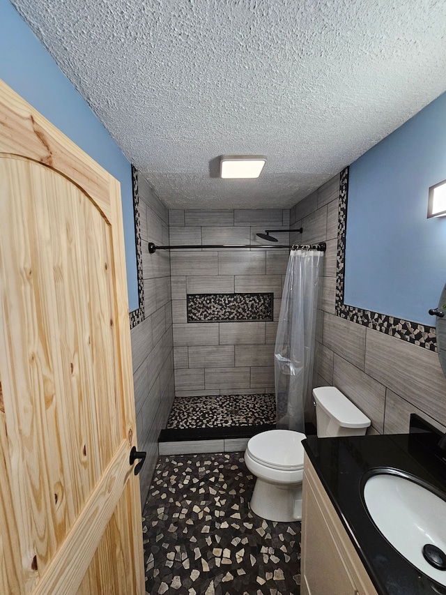 bathroom featuring a textured ceiling, vanity, tile walls, and a shower with shower curtain