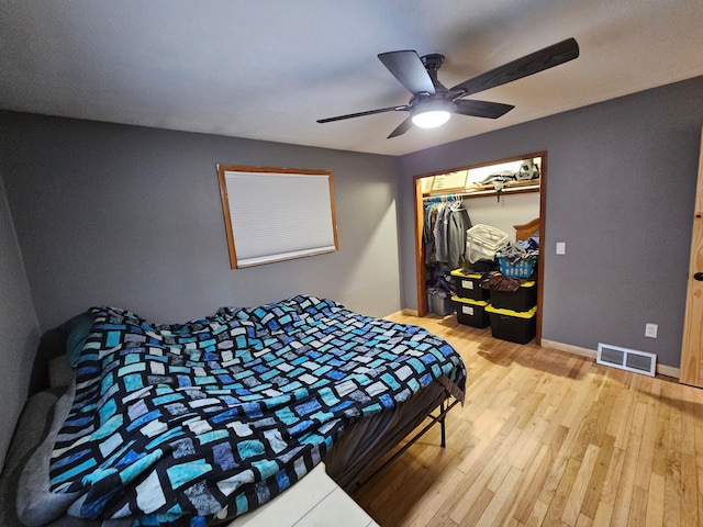 bedroom with a closet, light hardwood / wood-style flooring, and ceiling fan