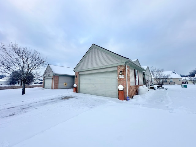 view of snowy exterior featuring a garage