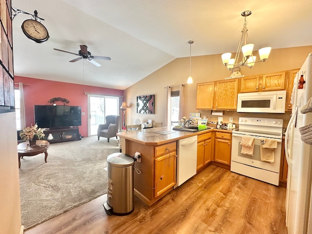 kitchen with white appliances, lofted ceiling, ceiling fan with notable chandelier, decorative light fixtures, and kitchen peninsula