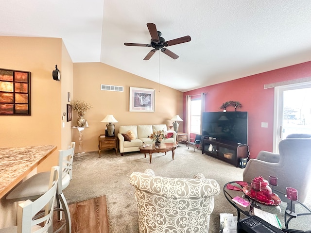 carpeted living room with ceiling fan and lofted ceiling