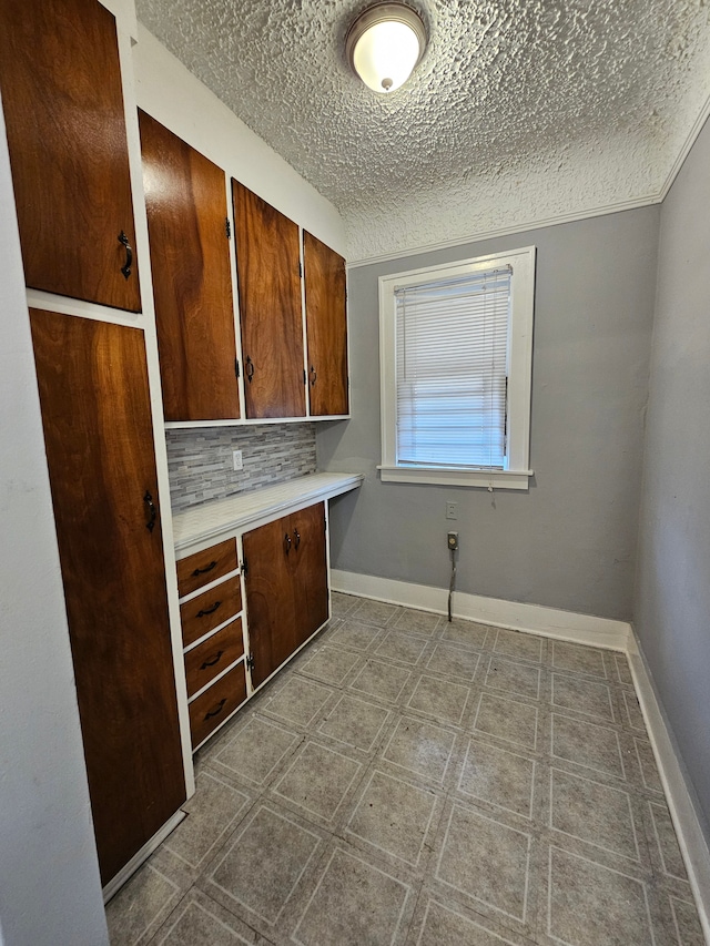 interior space with a textured ceiling and backsplash