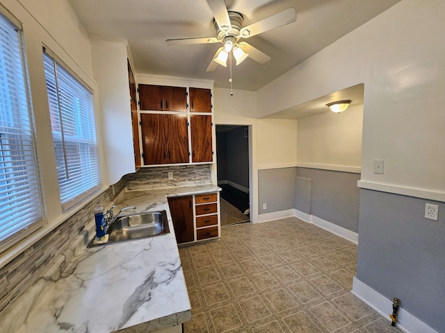 kitchen featuring tasteful backsplash, sink, and ceiling fan