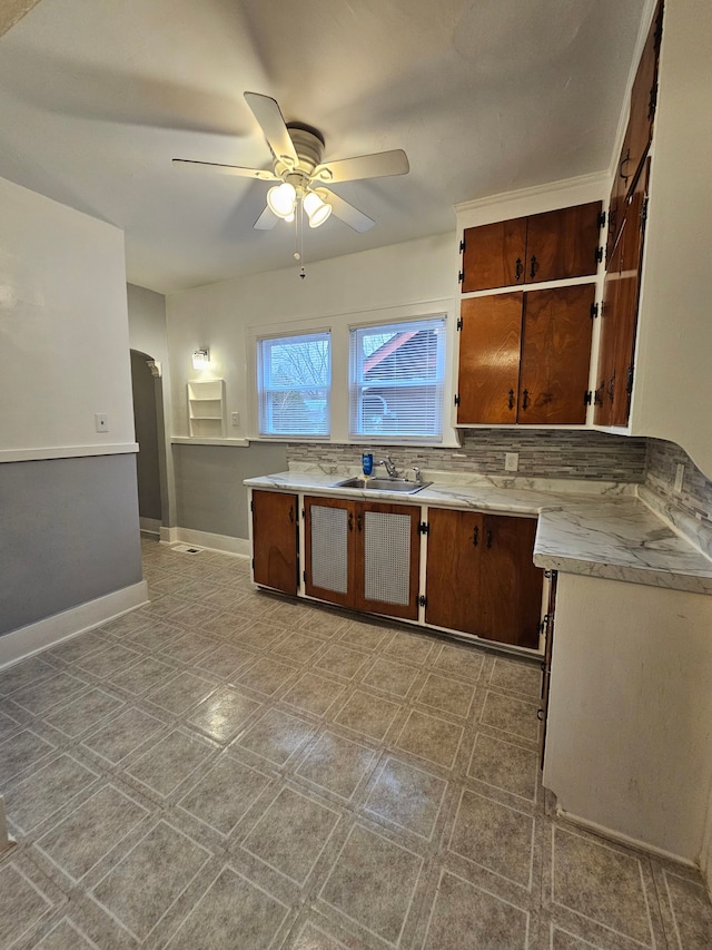 kitchen featuring tasteful backsplash, sink, and ceiling fan