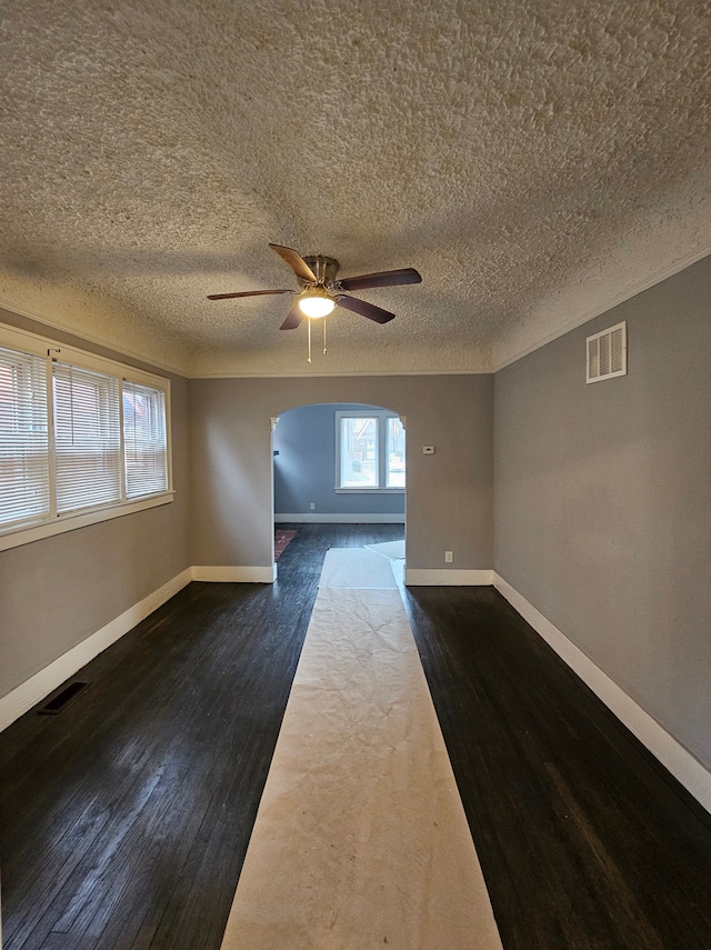 unfurnished room featuring dark hardwood / wood-style flooring, a textured ceiling, and ceiling fan