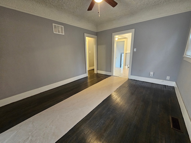 empty room featuring crown molding, a textured ceiling, dark hardwood / wood-style floors, and ceiling fan