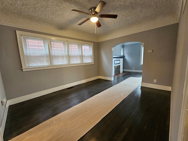 unfurnished room with dark hardwood / wood-style flooring, plenty of natural light, and ceiling fan