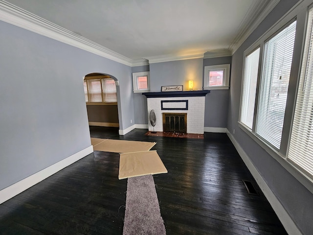 living room with ornamental molding, a brick fireplace, and dark hardwood / wood-style floors