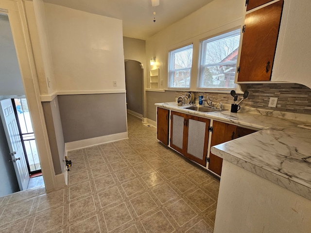 kitchen with tasteful backsplash, ceiling fan, and sink