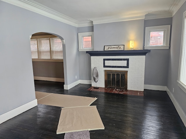 unfurnished living room featuring dark wood-type flooring, ornamental molding, and a fireplace