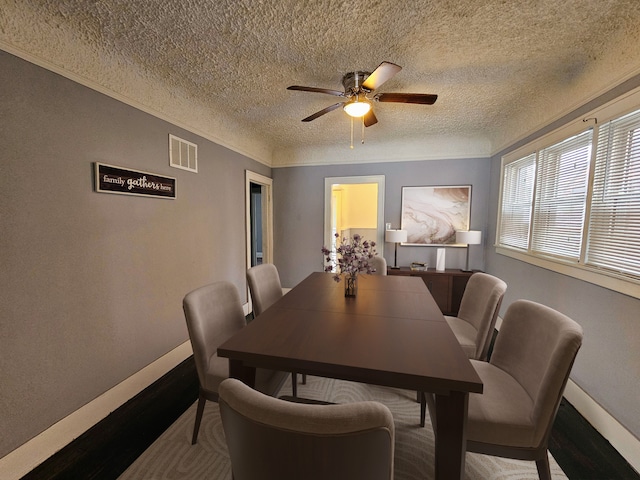 dining room with ceiling fan, ornamental molding, and a textured ceiling