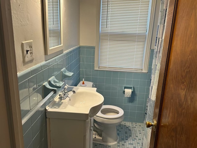 bathroom with tile patterned floors, vanity, tile walls, and toilet