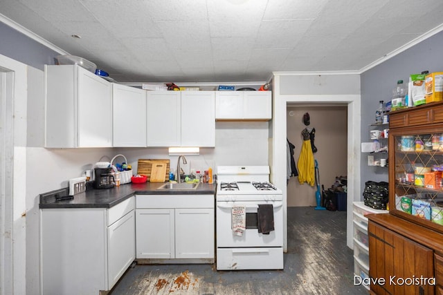 kitchen with white gas range, ornamental molding, white cabinets, and sink