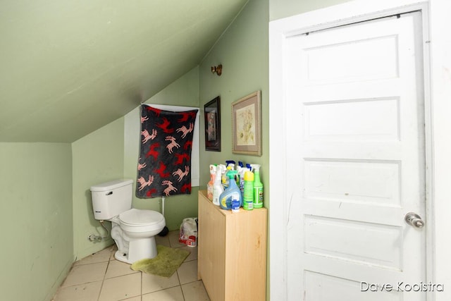 bathroom with toilet, vaulted ceiling, and tile patterned floors