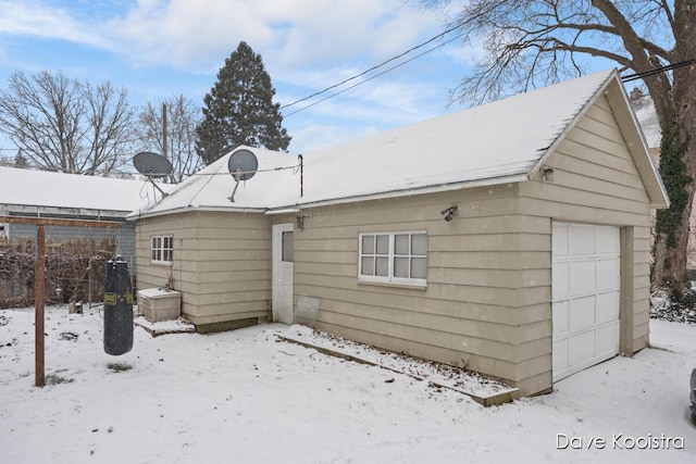 snow covered property with a garage