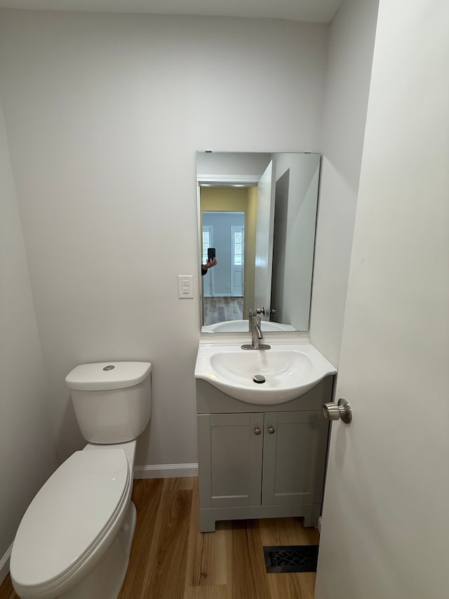 bathroom with vanity, hardwood / wood-style flooring, and toilet