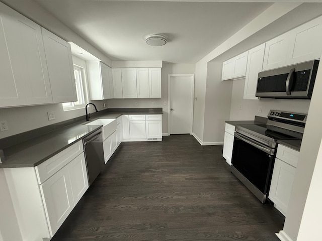 kitchen with dark hardwood / wood-style flooring, sink, white cabinetry, and stainless steel appliances