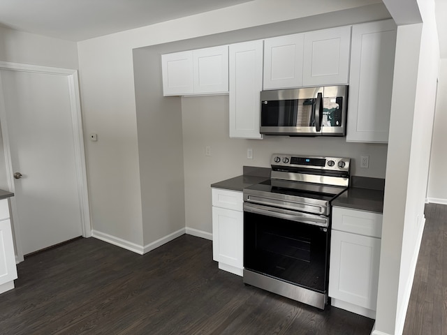 kitchen featuring dark hardwood / wood-style flooring, white cabinets, and appliances with stainless steel finishes