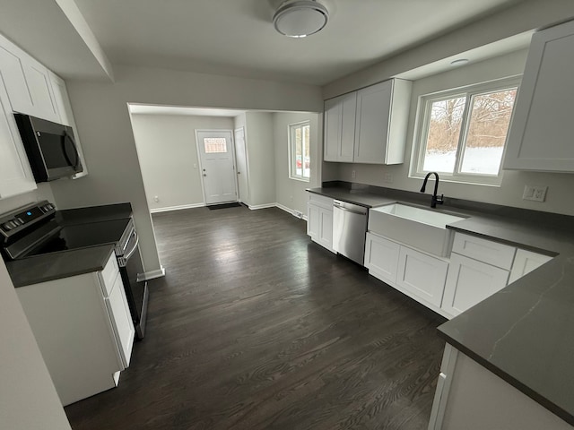 kitchen with dark hardwood / wood-style floors, white cabinetry, sink, and appliances with stainless steel finishes