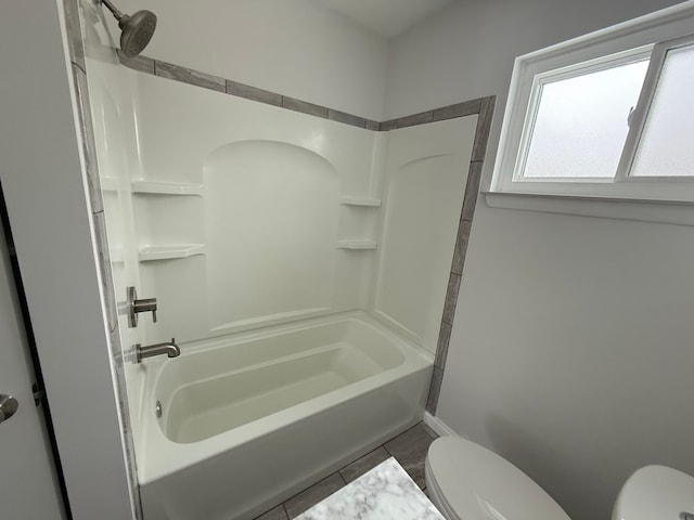 bathroom with tile patterned flooring, toilet, and washtub / shower combination