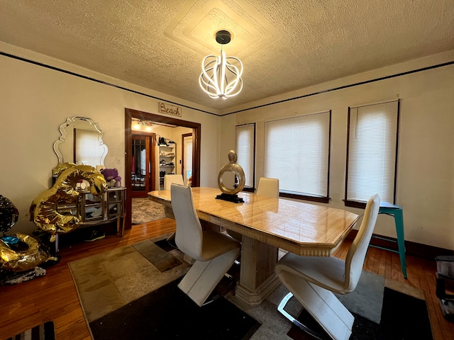 dining space with a chandelier, a textured ceiling, and dark hardwood / wood-style floors