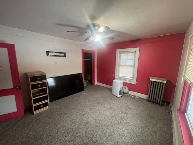 bedroom featuring ceiling fan, radiator heating unit, and carpet floors