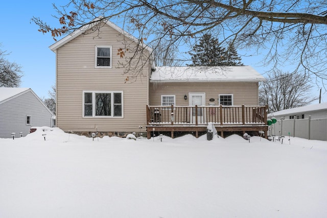 snow covered house with a wooden deck