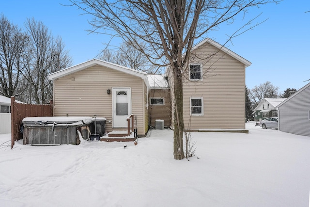 snow covered house featuring cooling unit