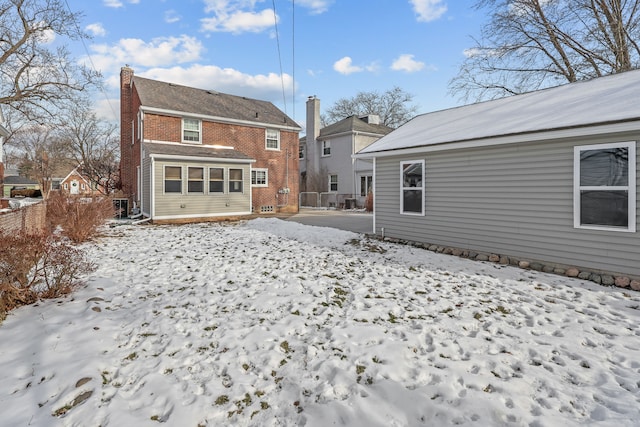 view of snow covered back of property