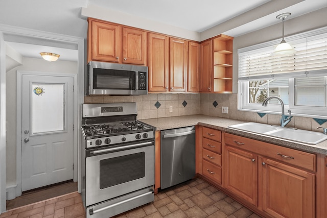 kitchen with sink, stainless steel appliances, tasteful backsplash, and decorative light fixtures