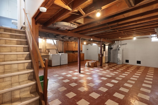 basement with heating unit, gas water heater, and independent washer and dryer