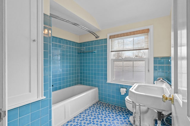 bathroom with tile patterned floors, toilet, shower / bathtub combination, and tile walls