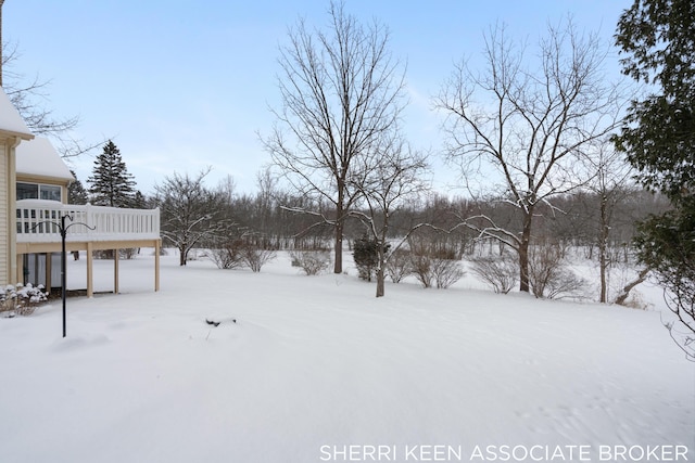 yard covered in snow featuring a wooden deck