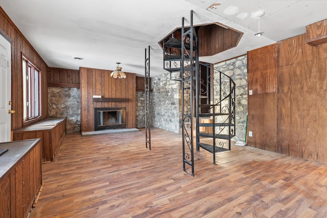 unfurnished living room featuring hardwood / wood-style floors and wooden walls