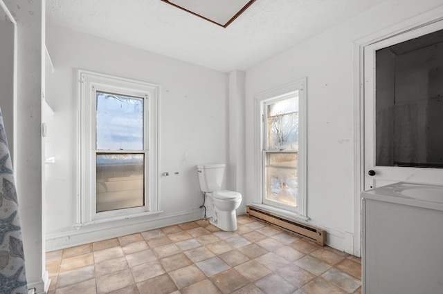 bathroom with baseboard heating, a textured ceiling, and toilet