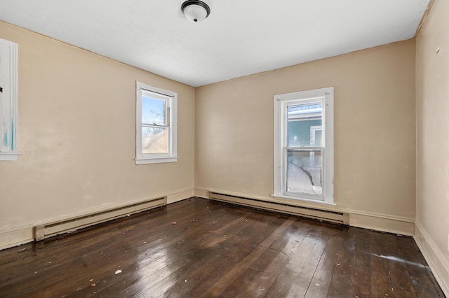 spare room with dark hardwood / wood-style flooring and a baseboard heating unit