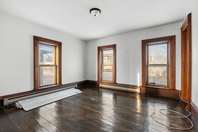 spare room featuring wood-type flooring and a baseboard radiator