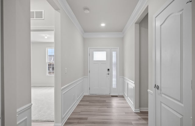 foyer entrance featuring light hardwood / wood-style floors and crown molding