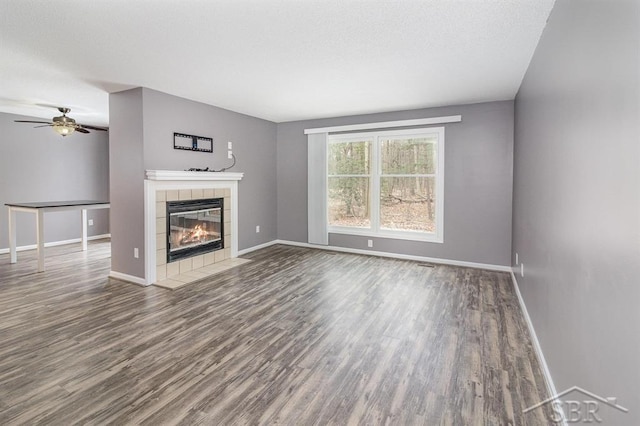 unfurnished living room with hardwood / wood-style floors, ceiling fan, and a fireplace