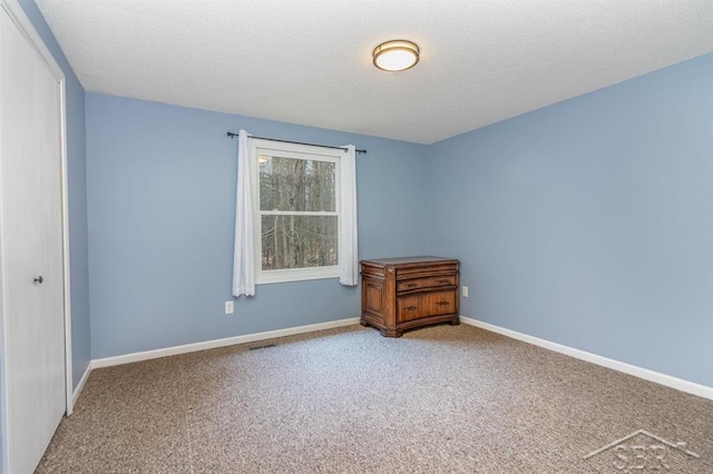 unfurnished bedroom featuring carpet flooring and a textured ceiling