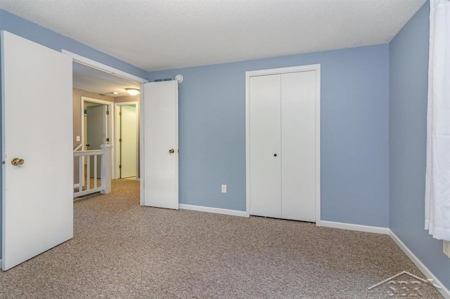 unfurnished bedroom featuring a textured ceiling, carpet floors, and a closet