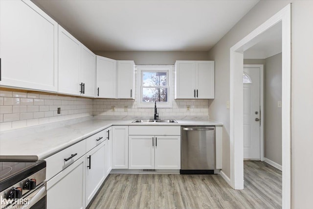 kitchen with backsplash, dishwasher, white cabinetry, and sink